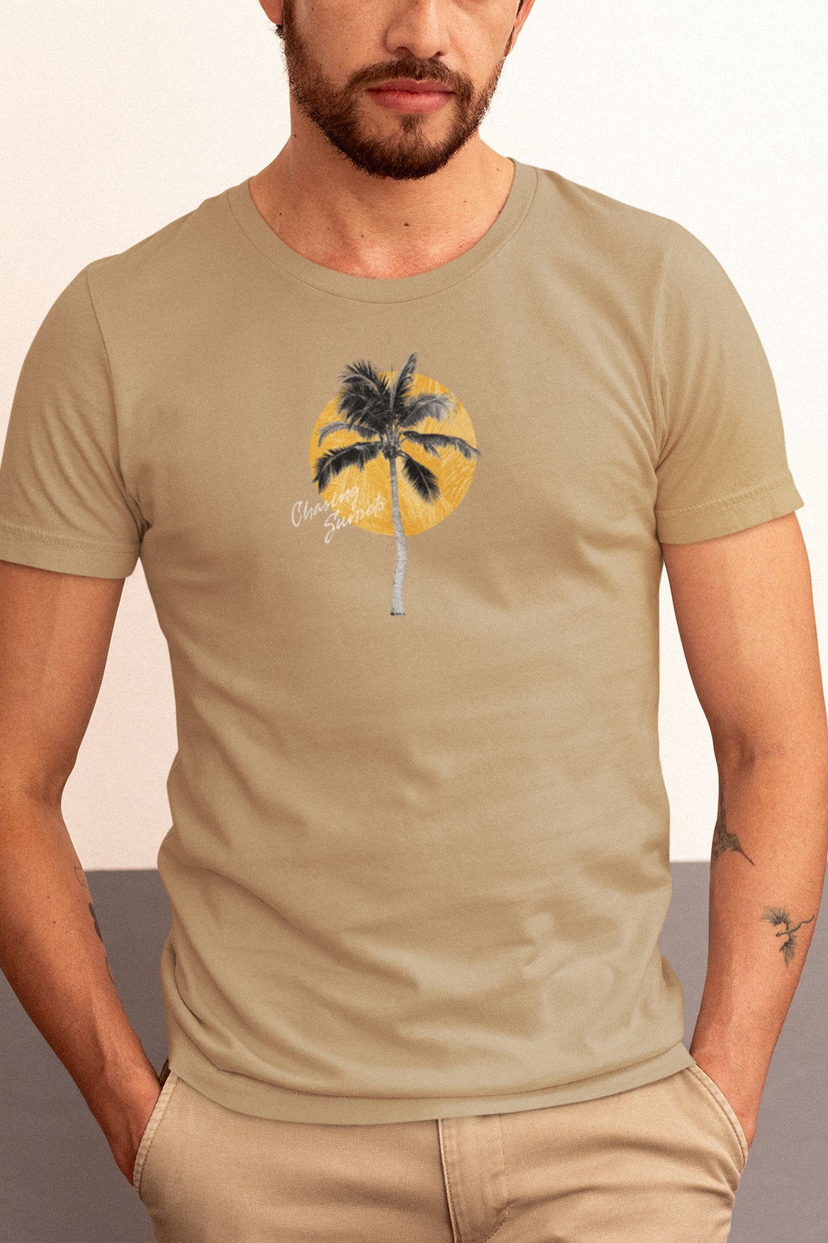 Man wearing a beige t-shirt with a palm tree design on a plain background