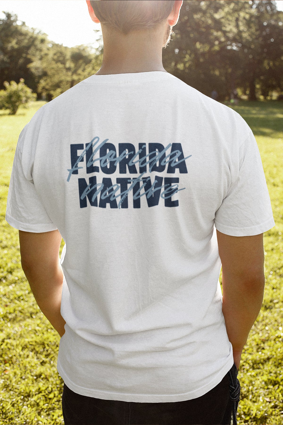Person wearing a white t-shirt with 'Florida Native' text on the back, standing in a grassy outdoor area.