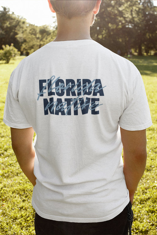 Person wearing a white t-shirt with 'Florida Native' text on the back, standing in a grassy outdoor area.